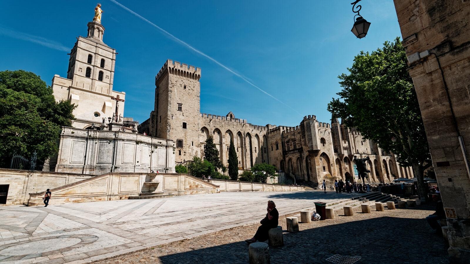 Palais des Papes and Notre-Dame des Doms rising above the stone expanse of Place du Palais