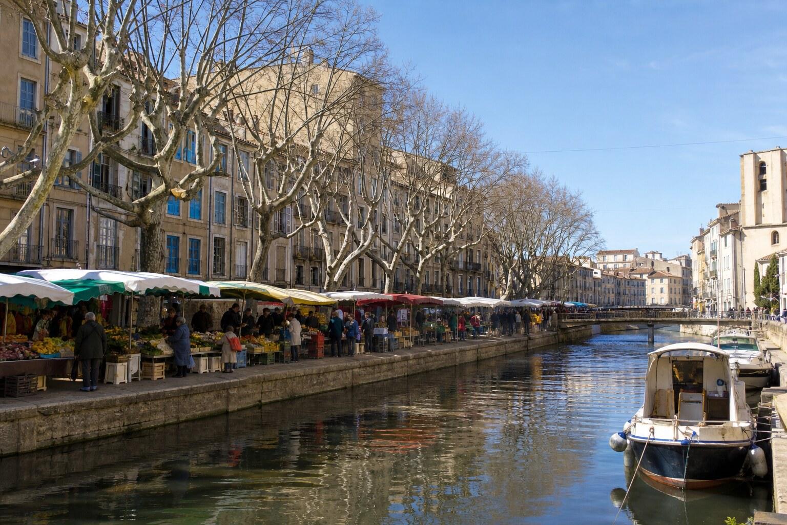 Boats and historic buildings beside the Canal de la Robine in Narbonne