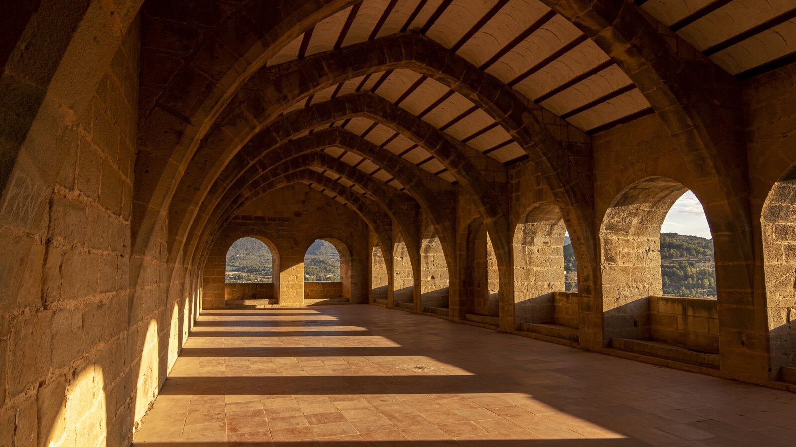 Sunlight crossing the ribbed stone gallery inside Valderrobres Castle